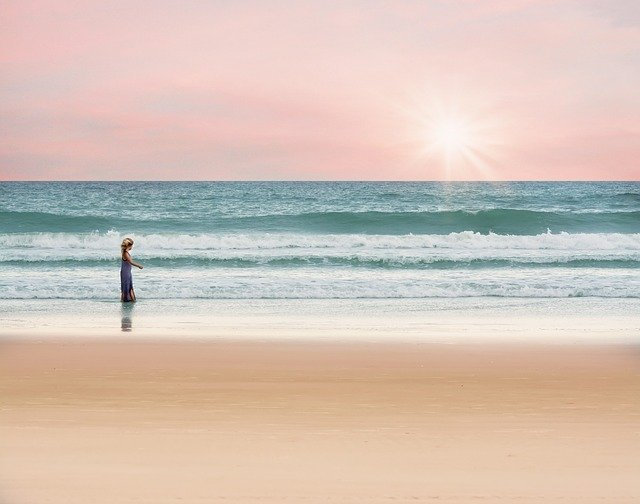 Una bambina cammina sulla spiaggia all'alba